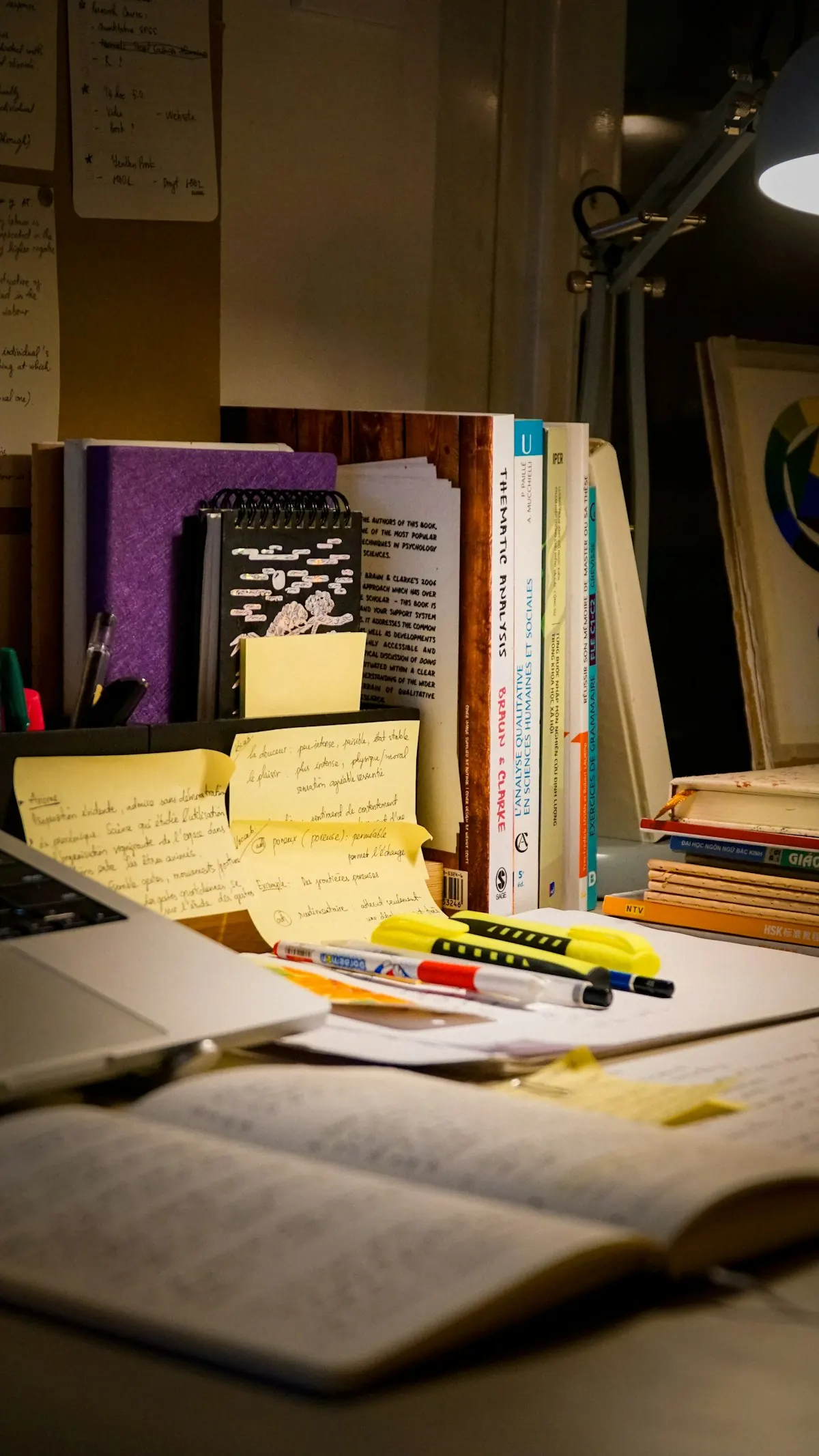 Open book, laptop and study materials on a desk