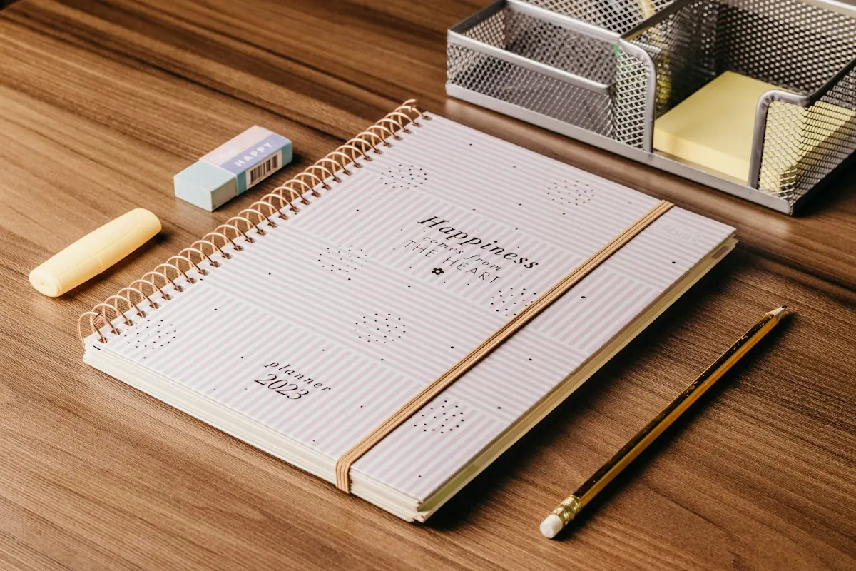 Notebook, pen and pencil arranged on a study desk
